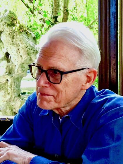 Photo of Rev. Barry Andrews. He is wearing a blue shirt, wears glasses and has white hair